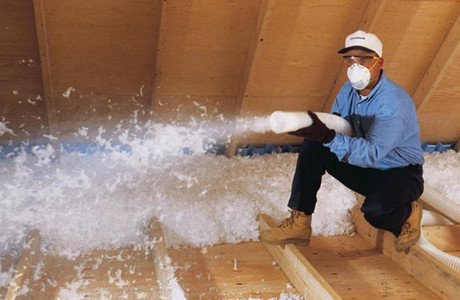 man spraying insulation in attic